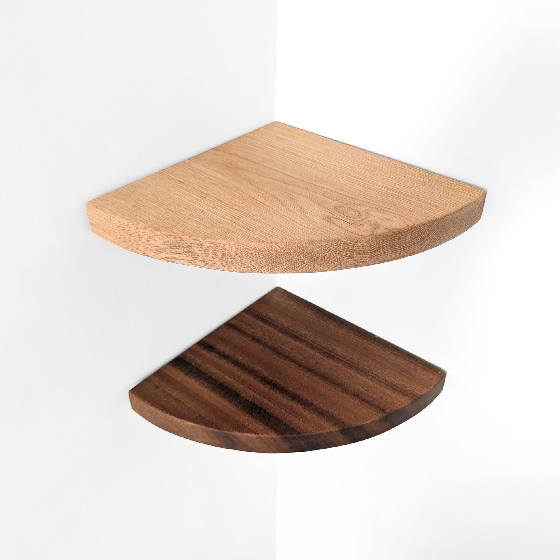 Top down view of solid wood corner shelves, one light wood and one dark wood, on a white background.