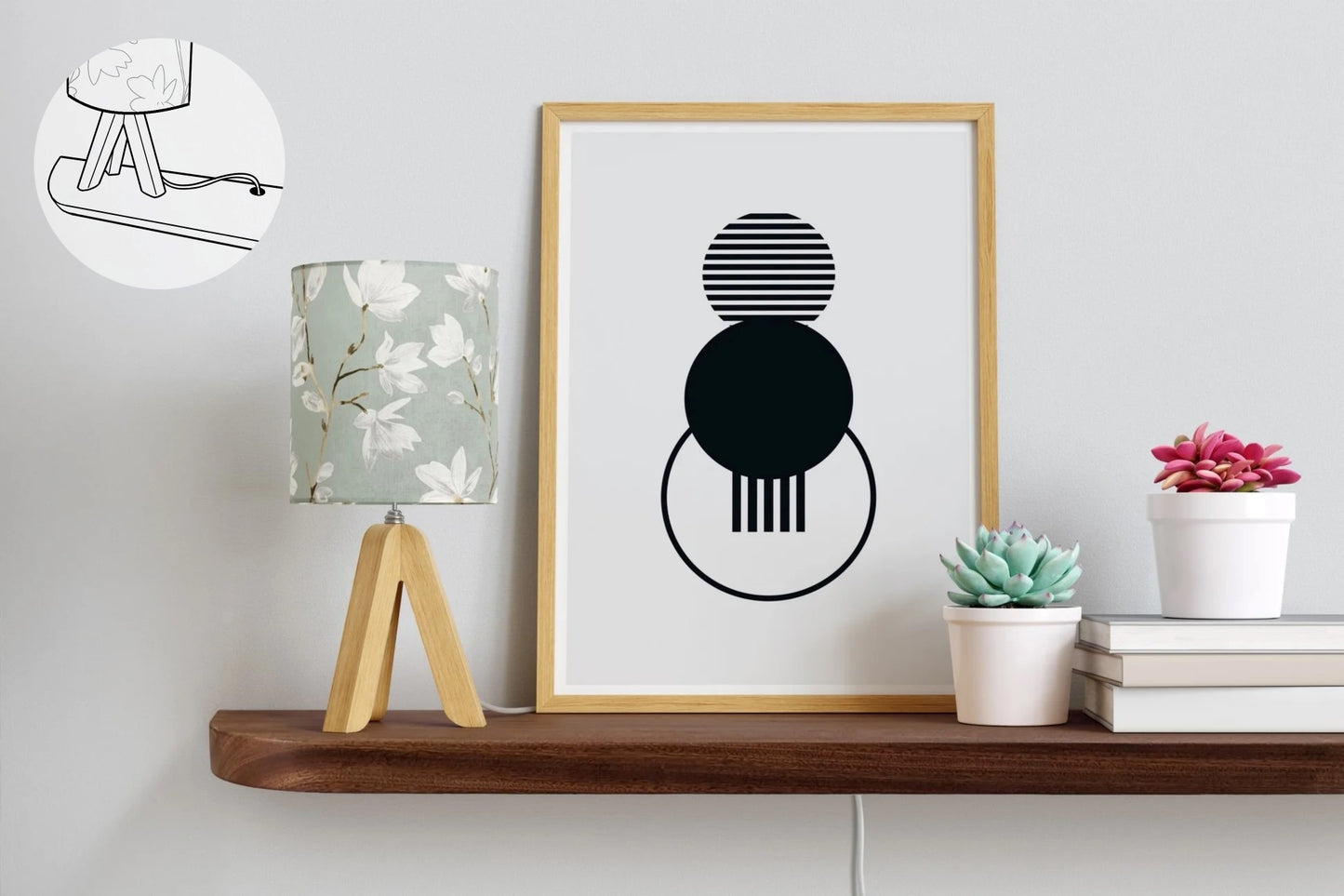 A mahogany floating shelf with rounded corners and a grommet hole is attached to a white wall with a lamp, picture, 3 books, and two plants on top as decor.