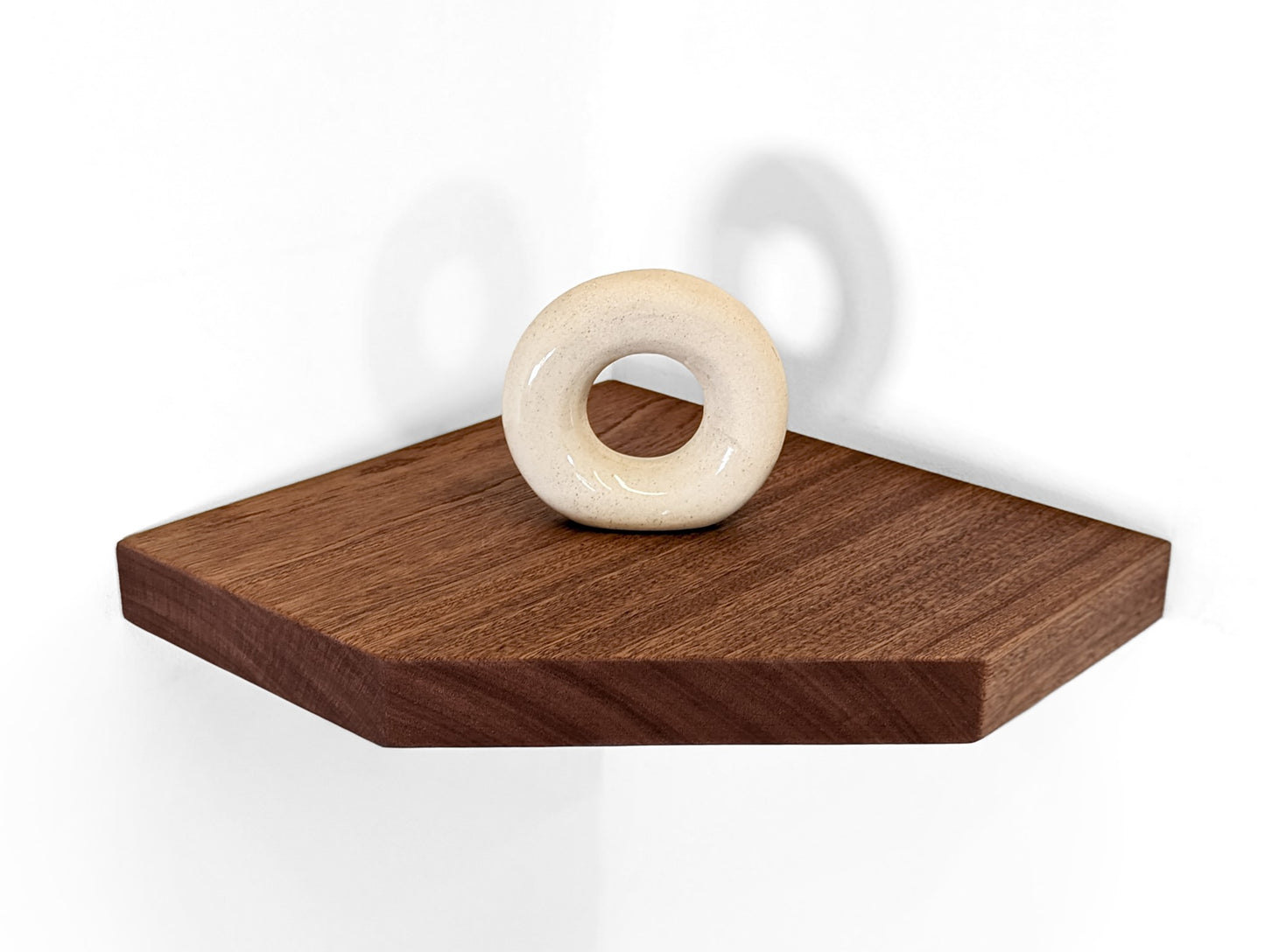 A mahogany corner shelf displays a ceramic donut.