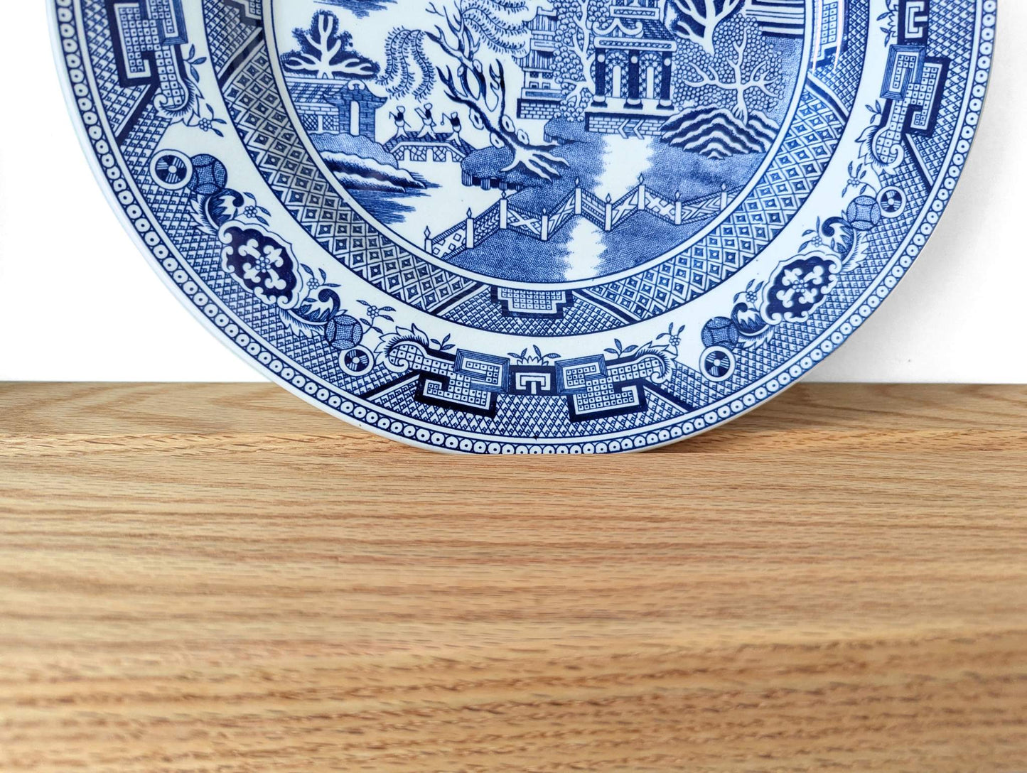 A decorative plate is displayed on a plate holder shelf.