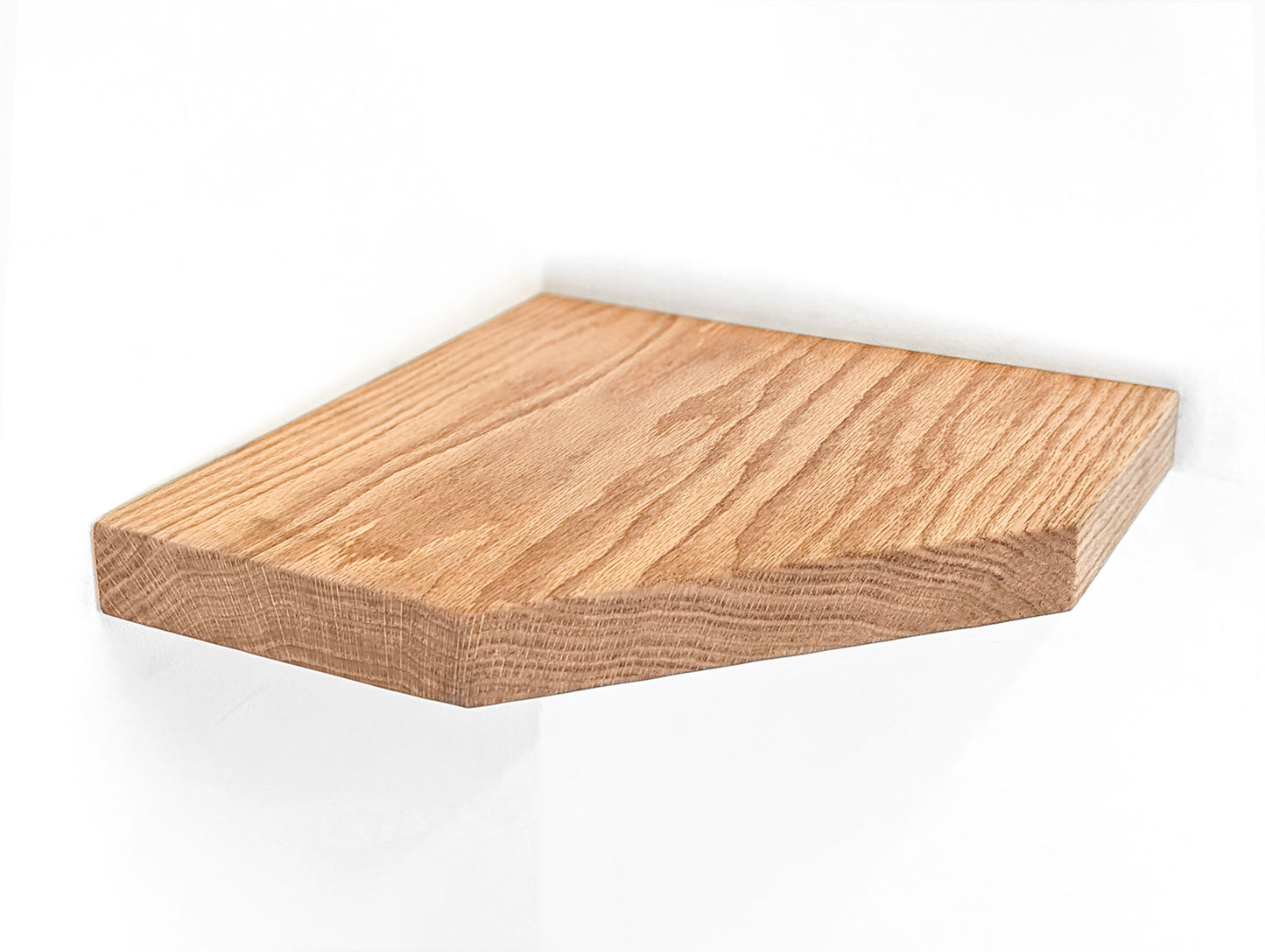 One large oak floating shelf with straight edges is attached a white wall.