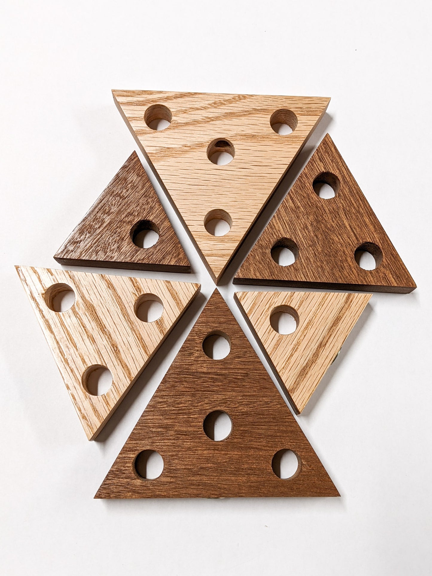 Various sized triangle propagation shelves are arranged on a white background. There is one of both oak and mahogany with 1 hole, three holes, and four holes.