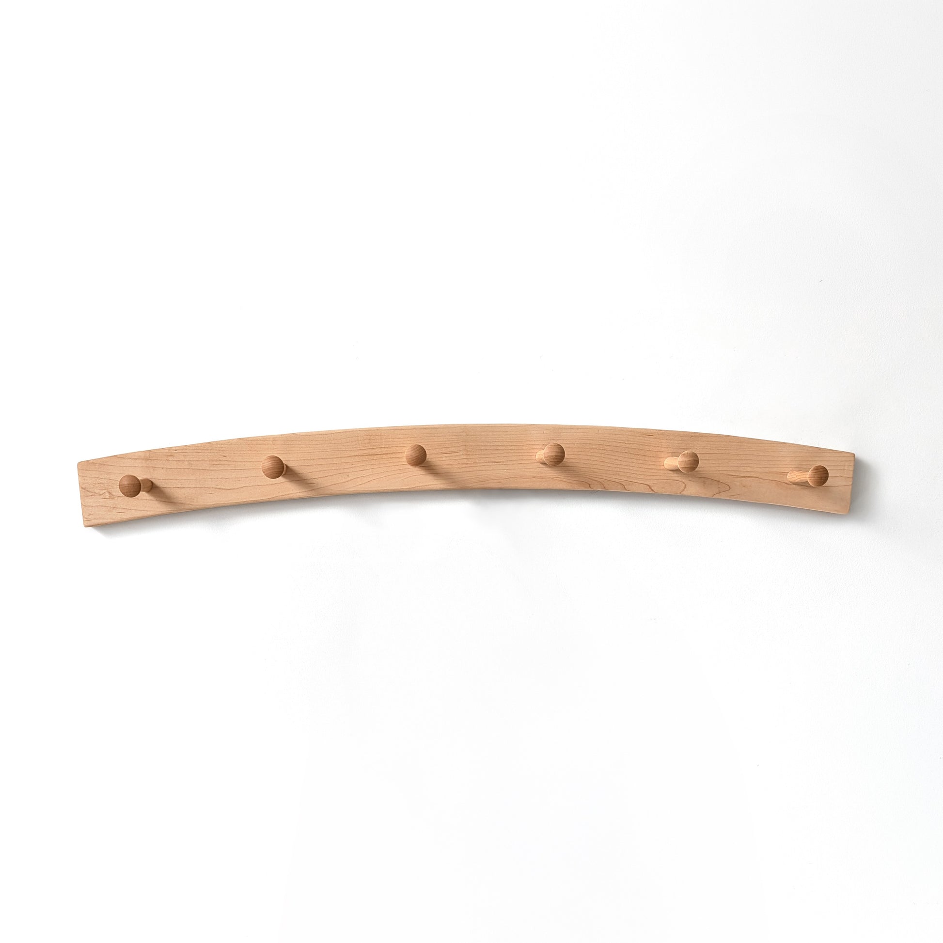 Arched maple coat rack with six hooks on a white background