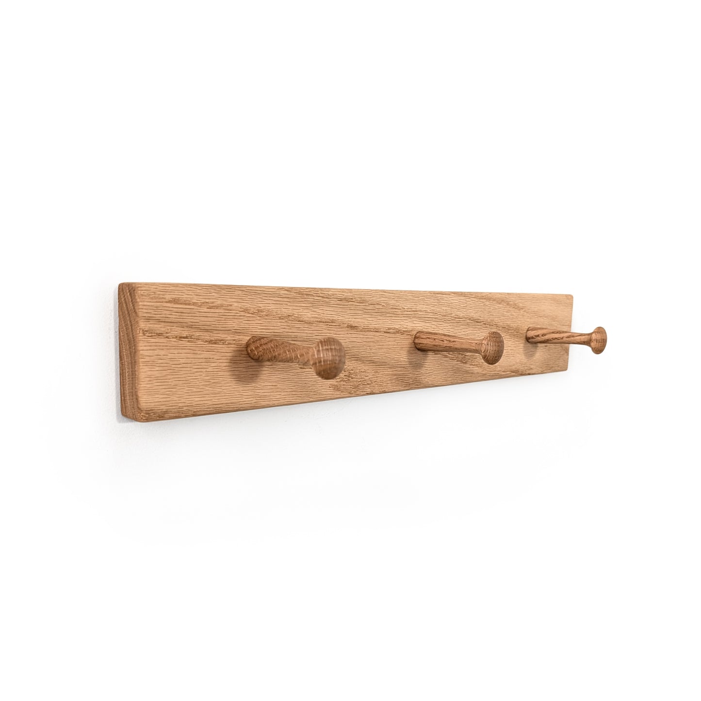 Wooden wall hook with three hooks on a white background