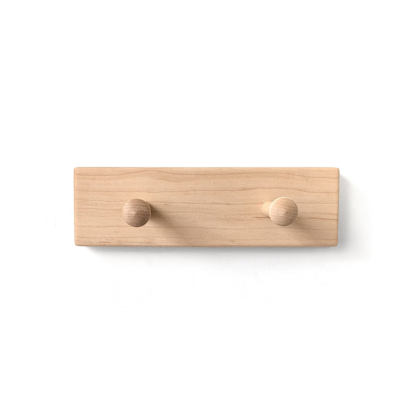 Maple wooden wall hook with two round protrusions on a white background