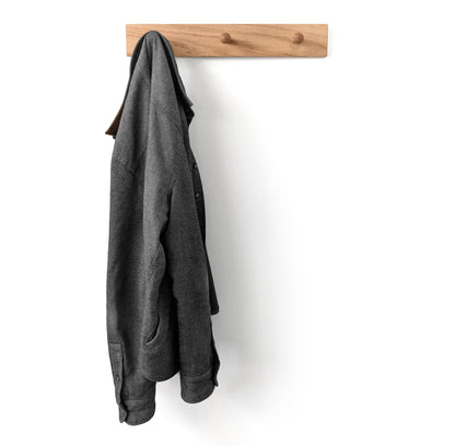 Gray coat hanging on a 3 peg wooden wall hook coat rack against a white background