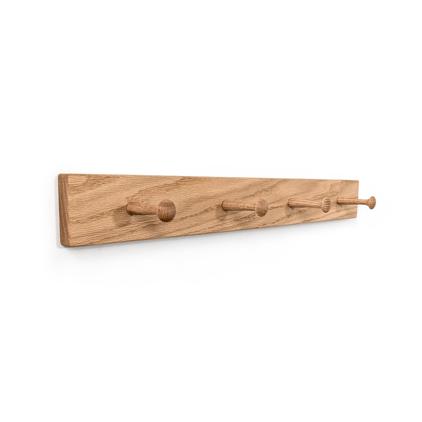 Wood coat rack with four oak hooks on a white background