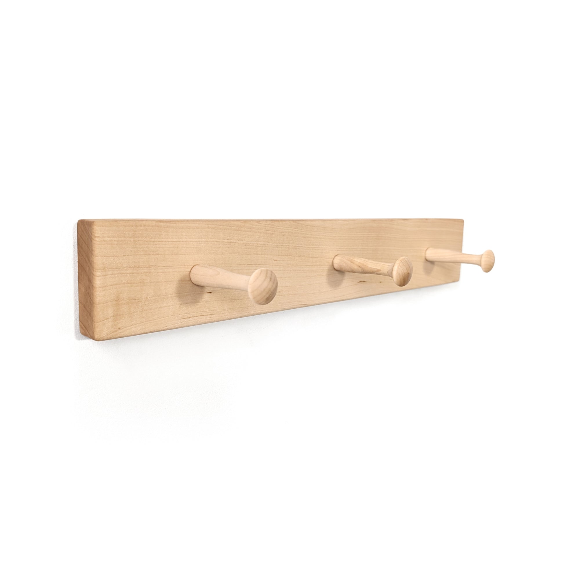 Wood coat rack with three peg hooks on a white background