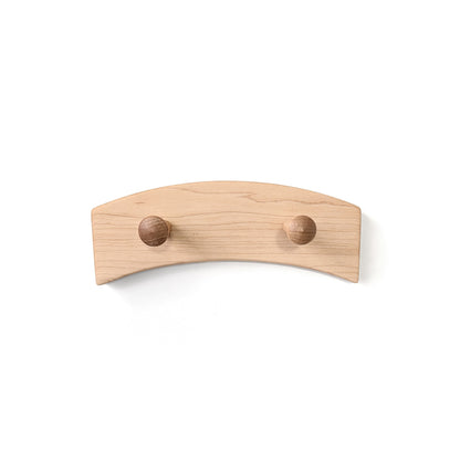 Wall-mounted wood coat rack with two round wooden pegs on a white background