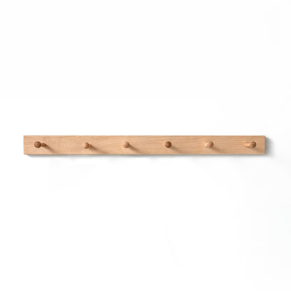 Wooden coat rack with six hooks on a white background