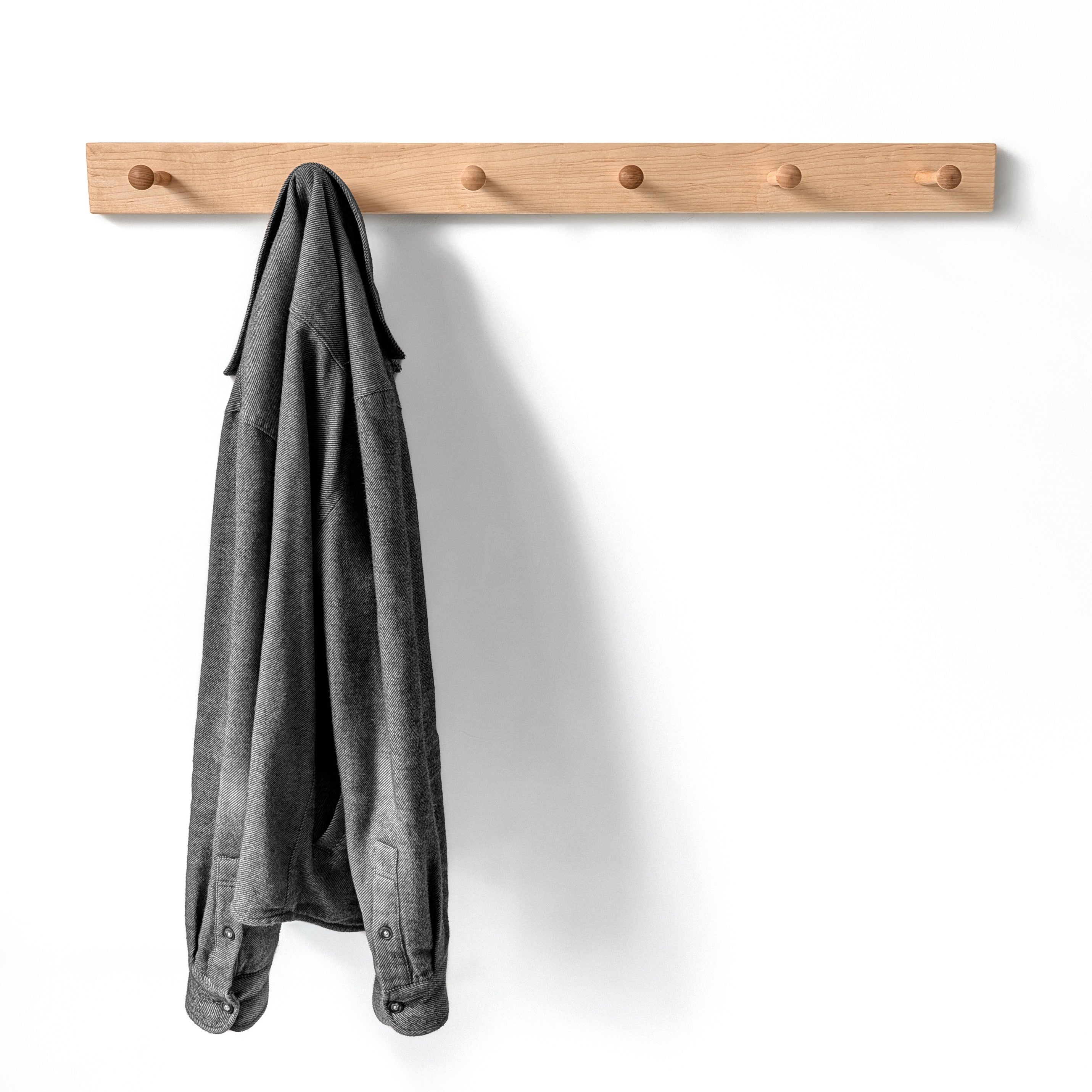 Classic maple wooden coat rack with a gray jacket on a white background, six shaker pegs