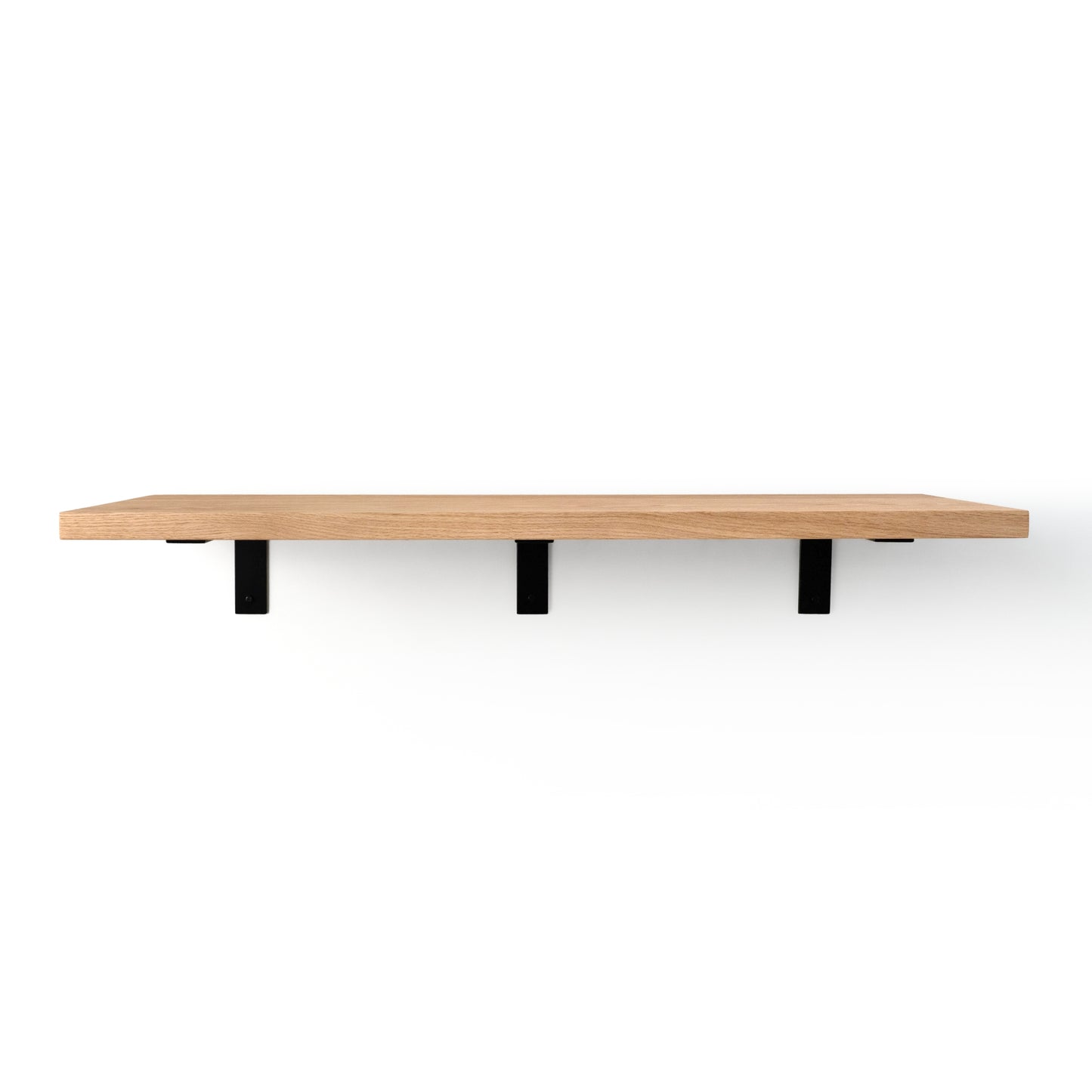 Wooden shelf with black brackets that are visible on a white background