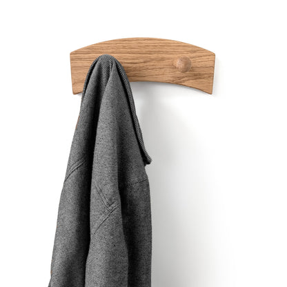 Wooden oak coat hook with a gray jacket on a white background