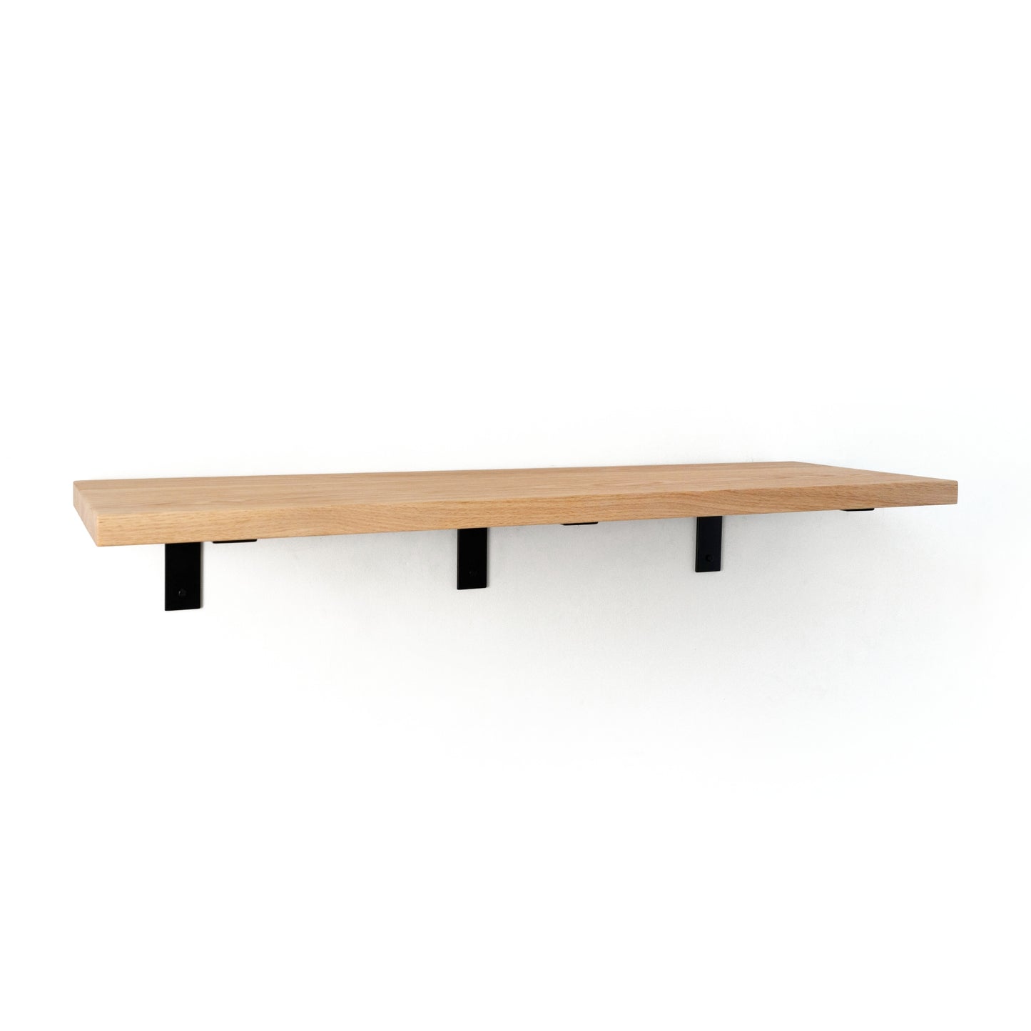 Wooden shelf with black brackets on a white background