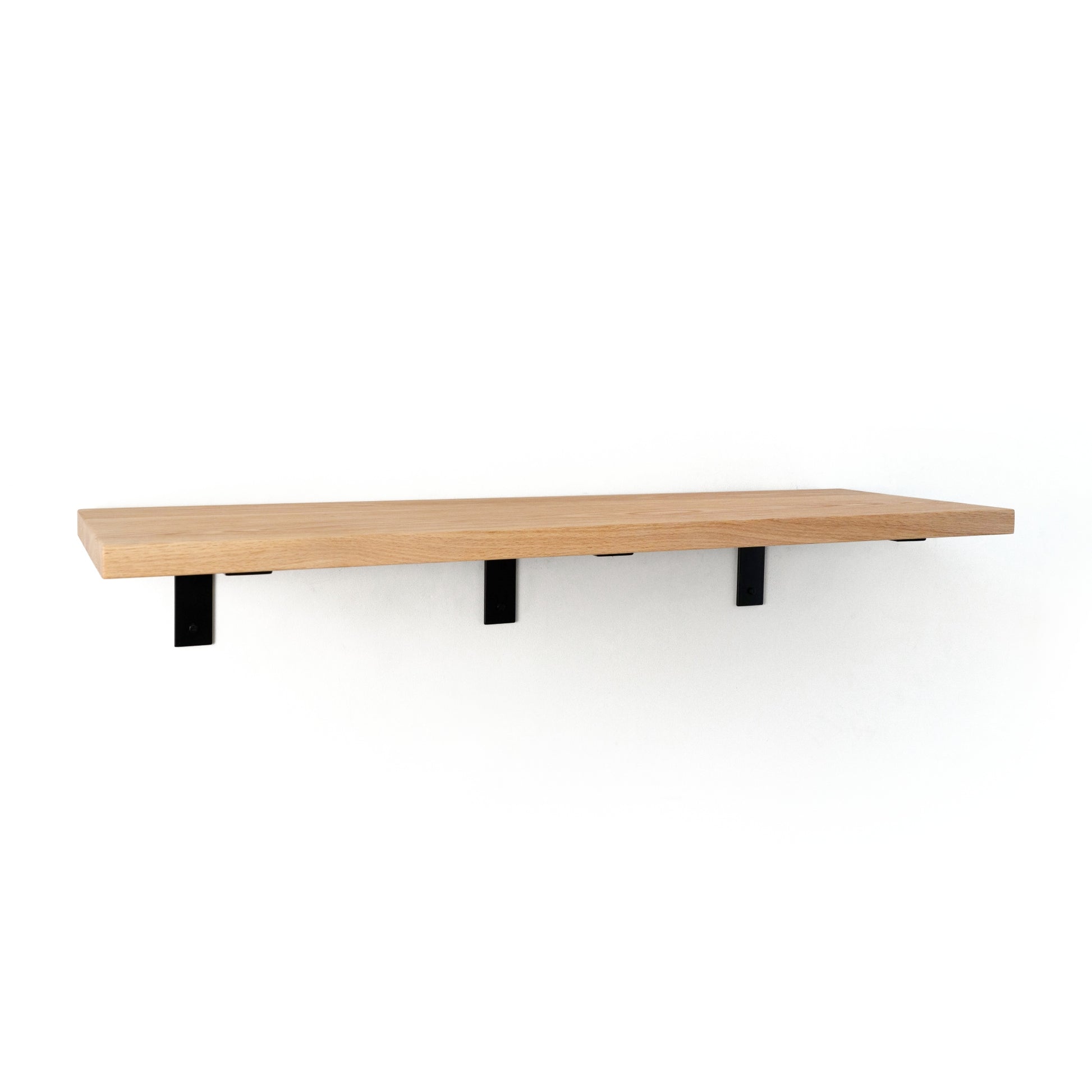 Wooden shelf with black brackets on a white background