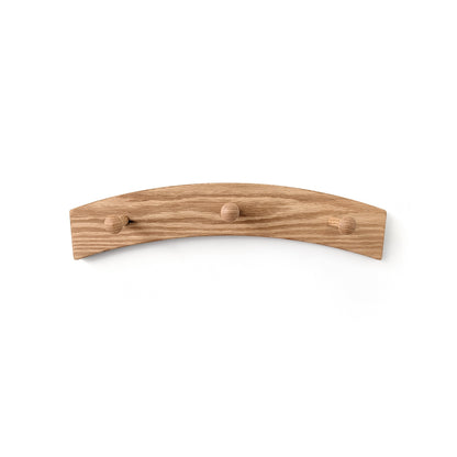 Three peg coat rack with an arch design on a white wall