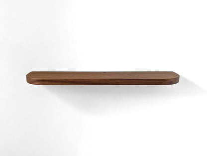Angled down photo of a mahogany shelf with rounded corners and a grommet hole