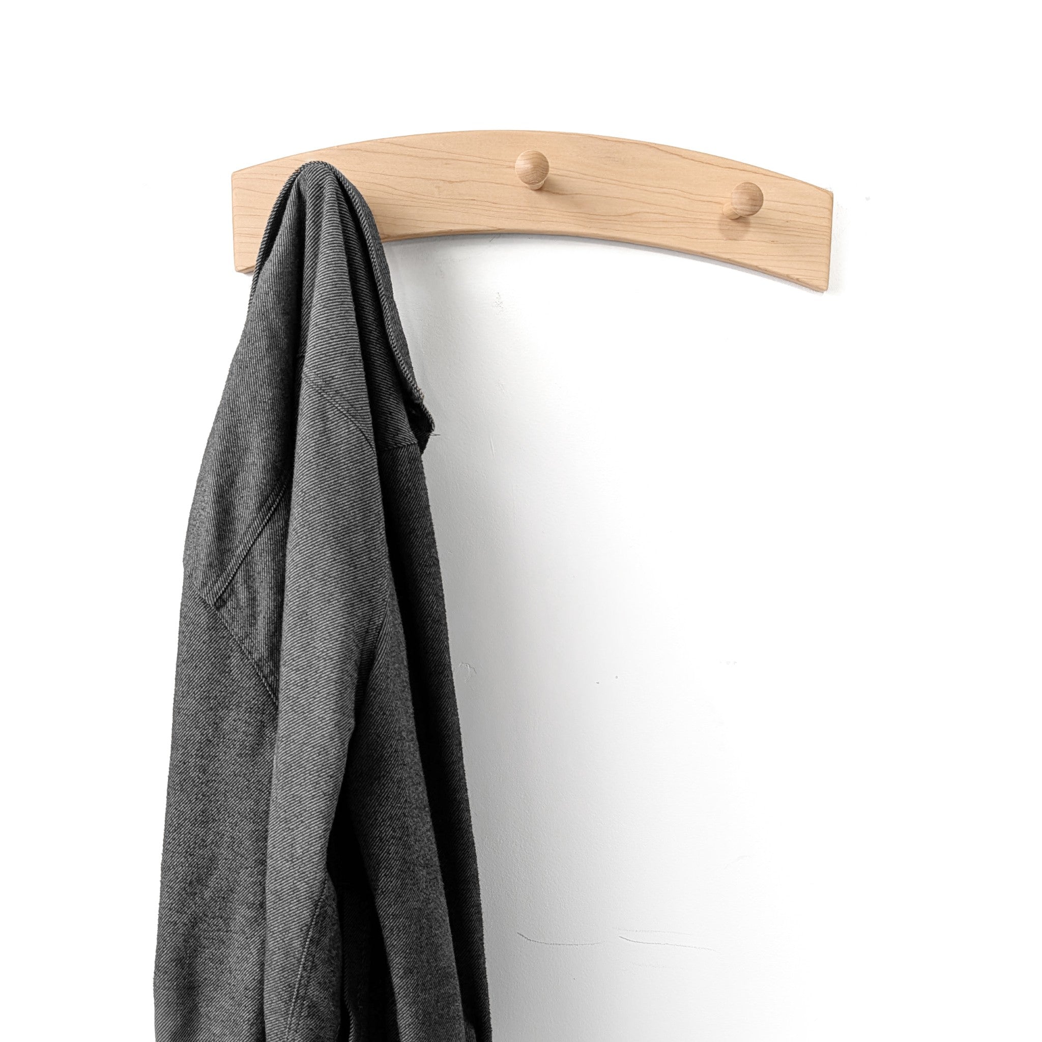 Three shaker peg coat rack with a gray jacket on a white background