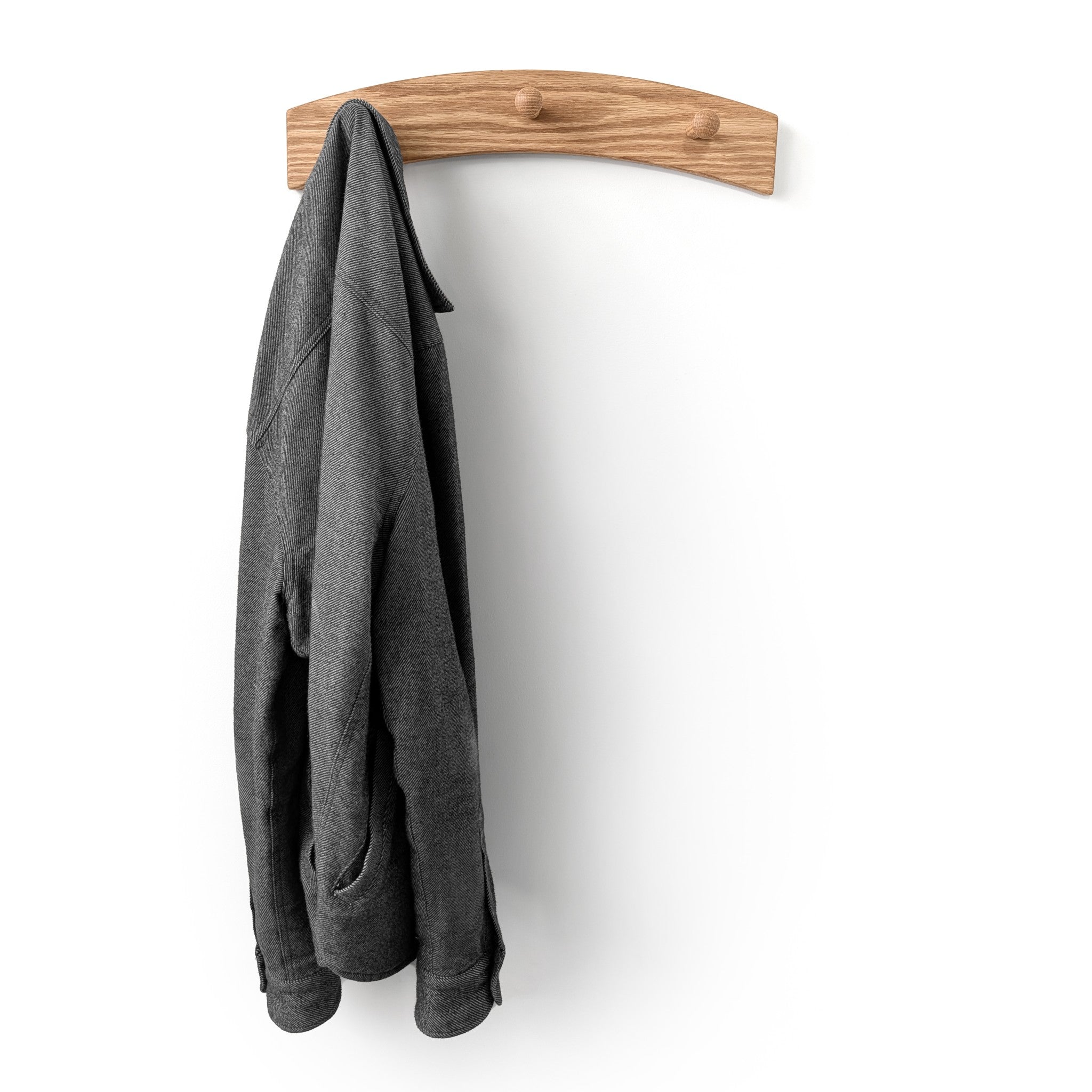 Gray jacket hanging on a wooden hook coat rack against a white background