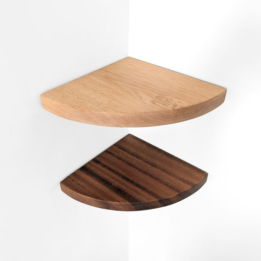 Top down view of solid wood corner shelves, one light wood and one dark wood, on a white background.