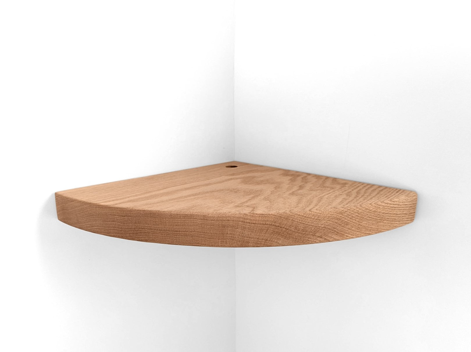 Thick oak floating shelf with a cord hole for wall corners is installed on a white wall.