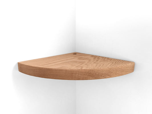 Thick oak floating shelf with a cord hole for wall corners is installed on a white wall.