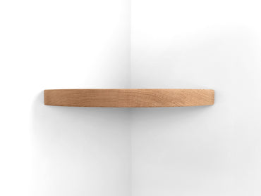 Front view of a thick oak corner floating shelf.