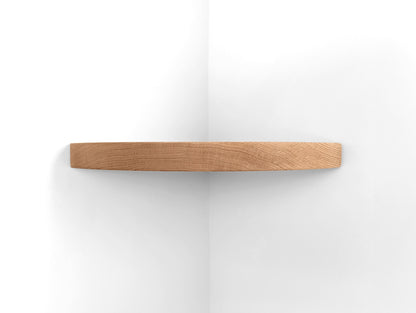 Front view of a thick oak corner floating shelf.