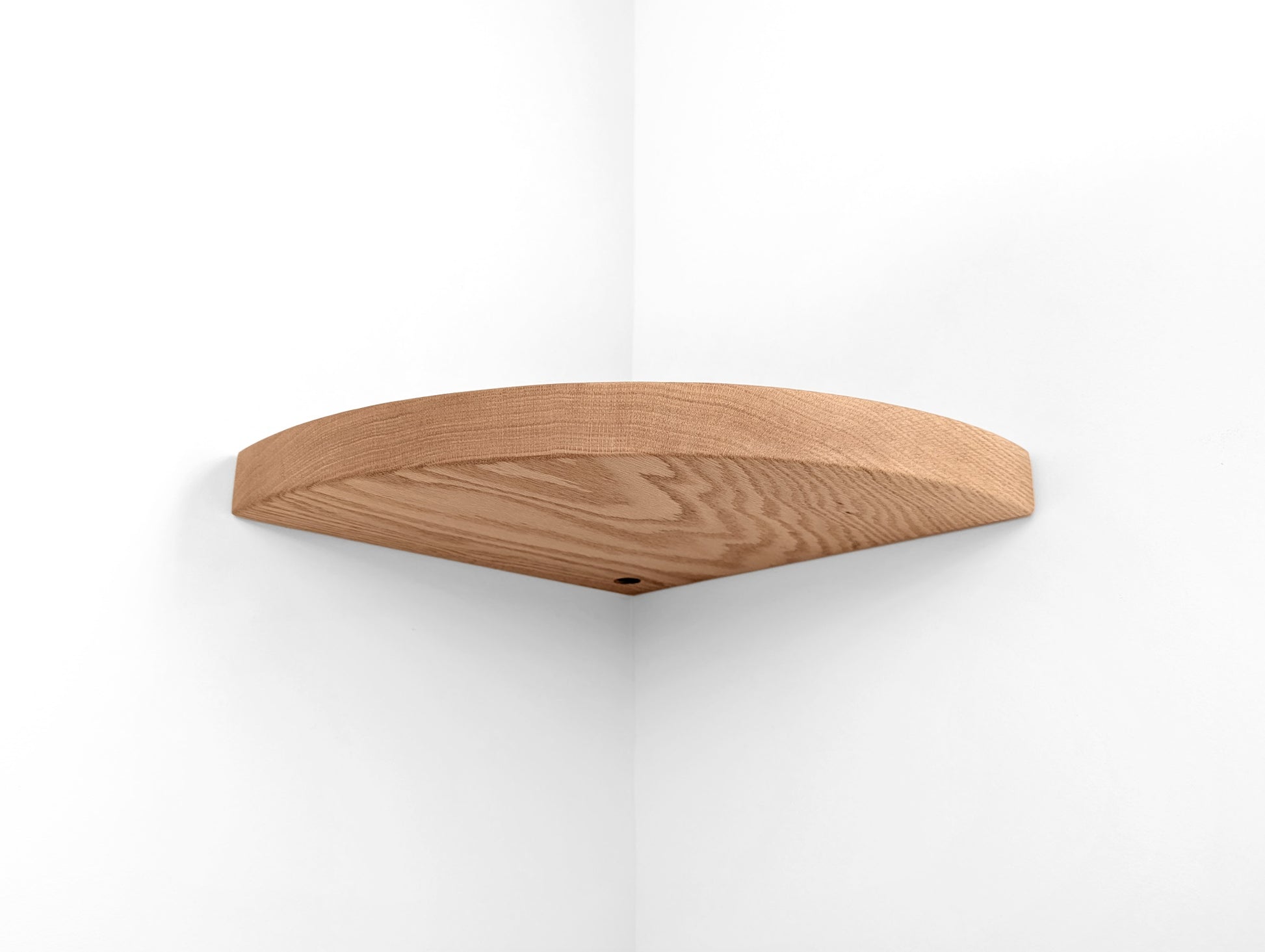 Bottom view of a oak floating shelf for corners with a grommet hole.