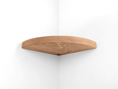 Bottom view of a oak floating shelf for corners with a grommet hole.