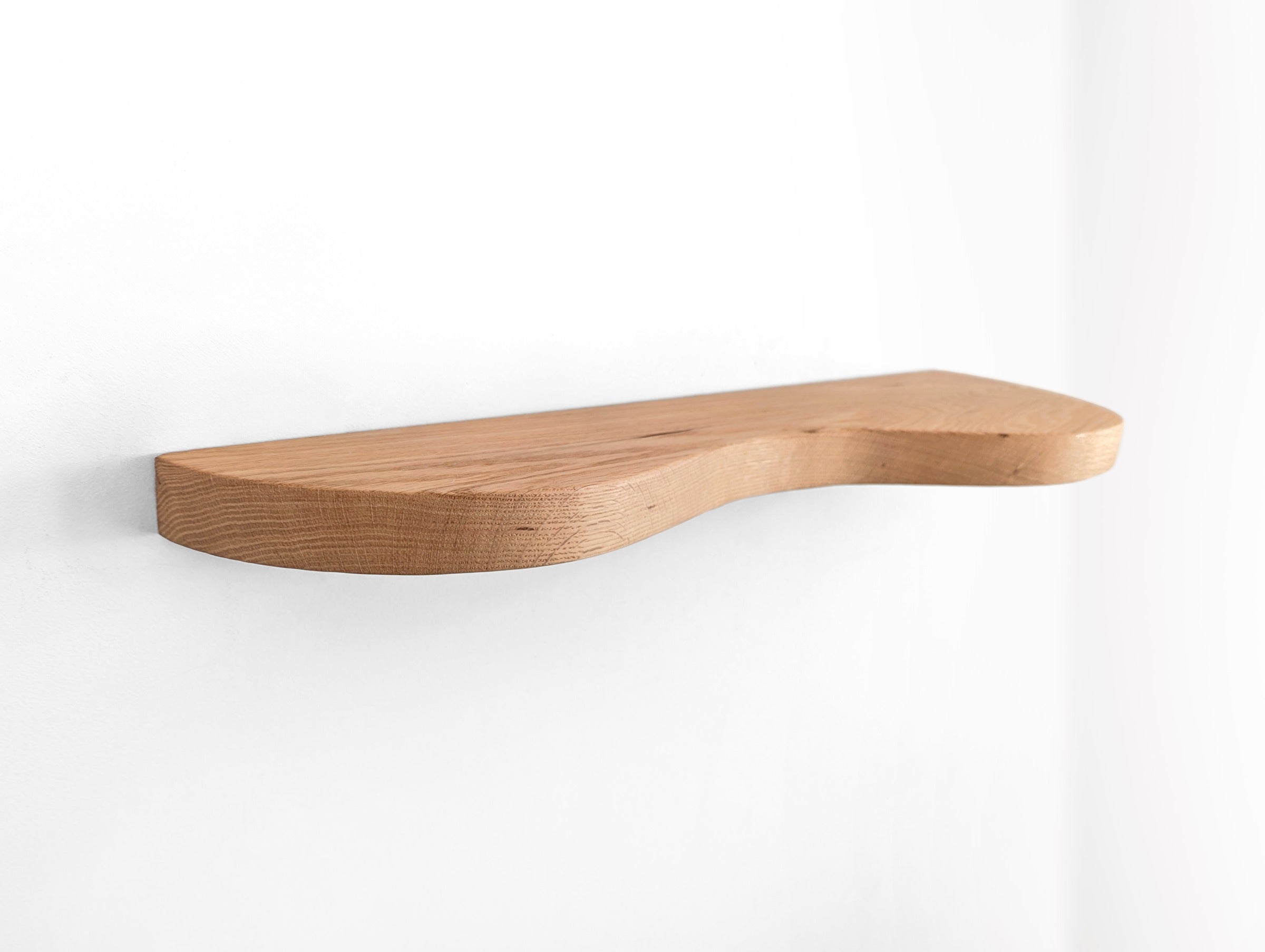An oak double curved floating shelf, photo taken on an upper angle