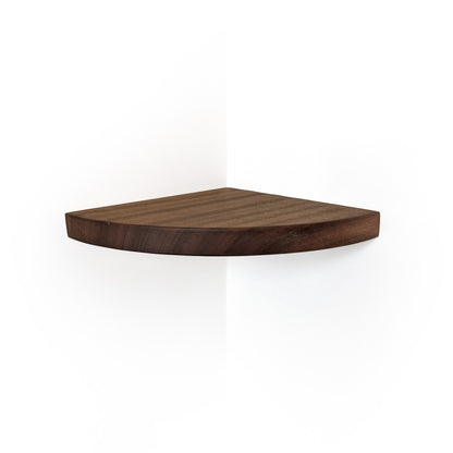 A triangular corner shelf made of dark brown walnut wood, shown mounted on a white wall corner with a soft shadow below.