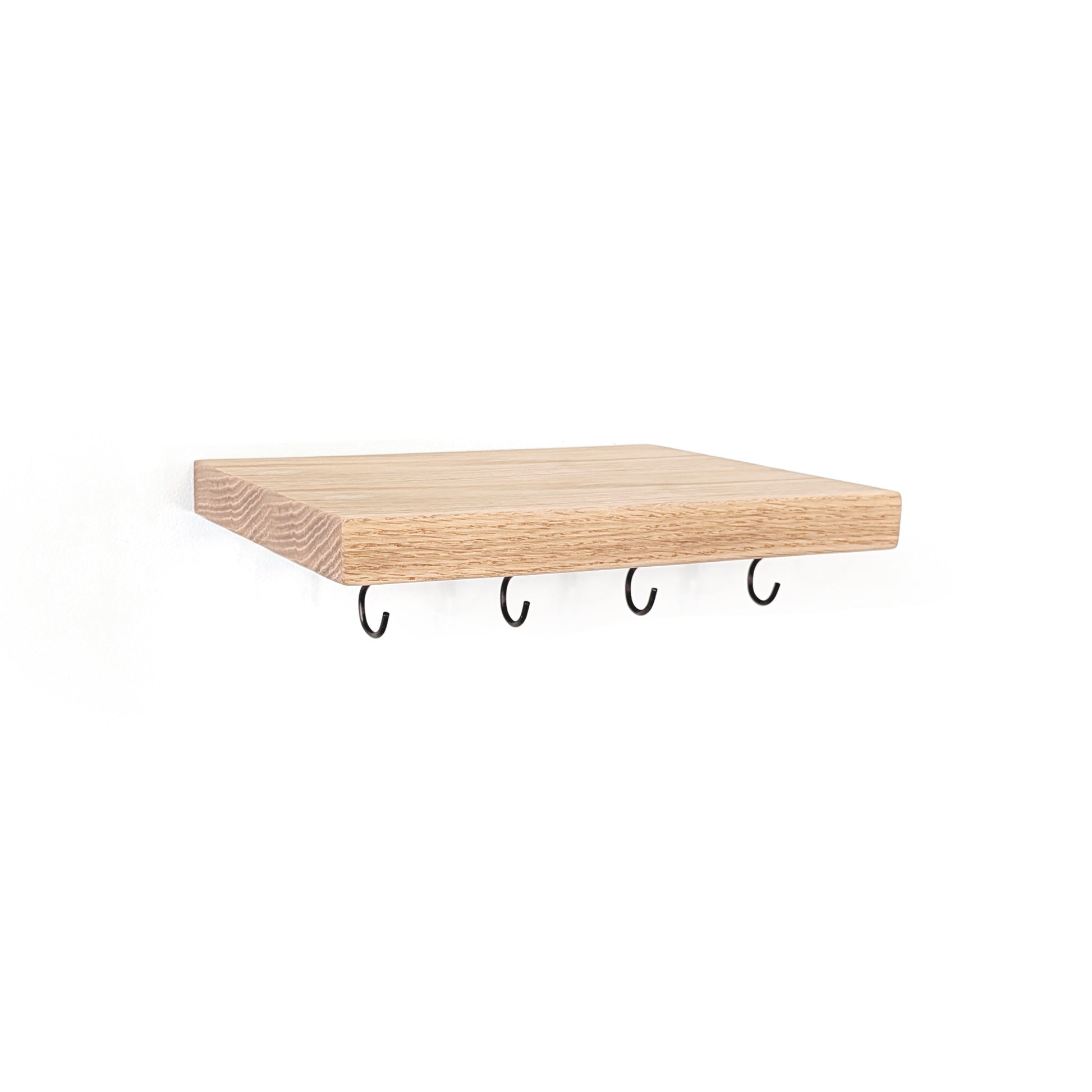 A rectangular light maple wood floating shelf with four black metal wall hooks hanging underneath, shown against a plain white background.