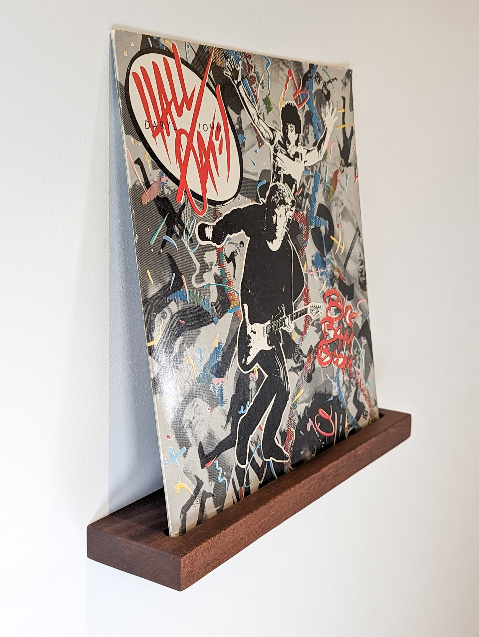 Side angled picture of a mahogany shelf with an album sleeve as decor.