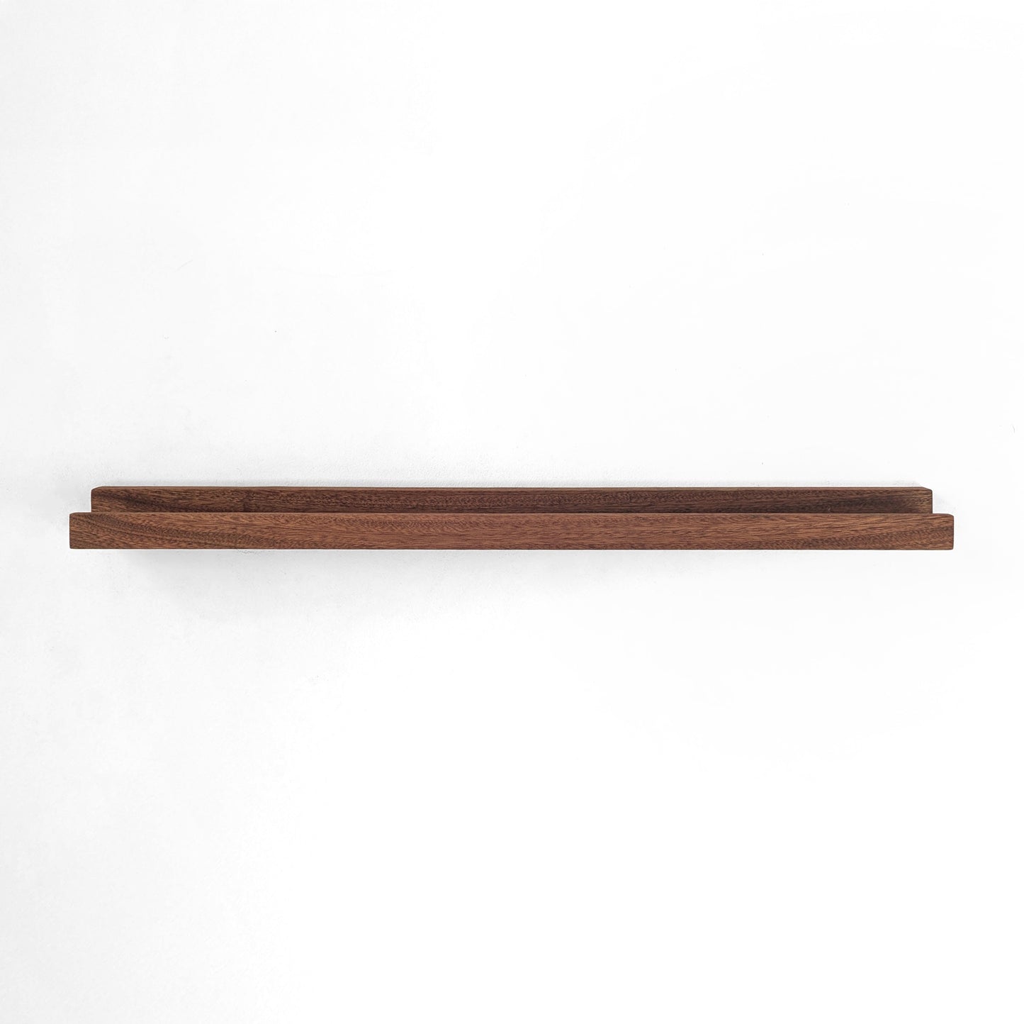 Straight view of a mahogany wooden picture shelf.