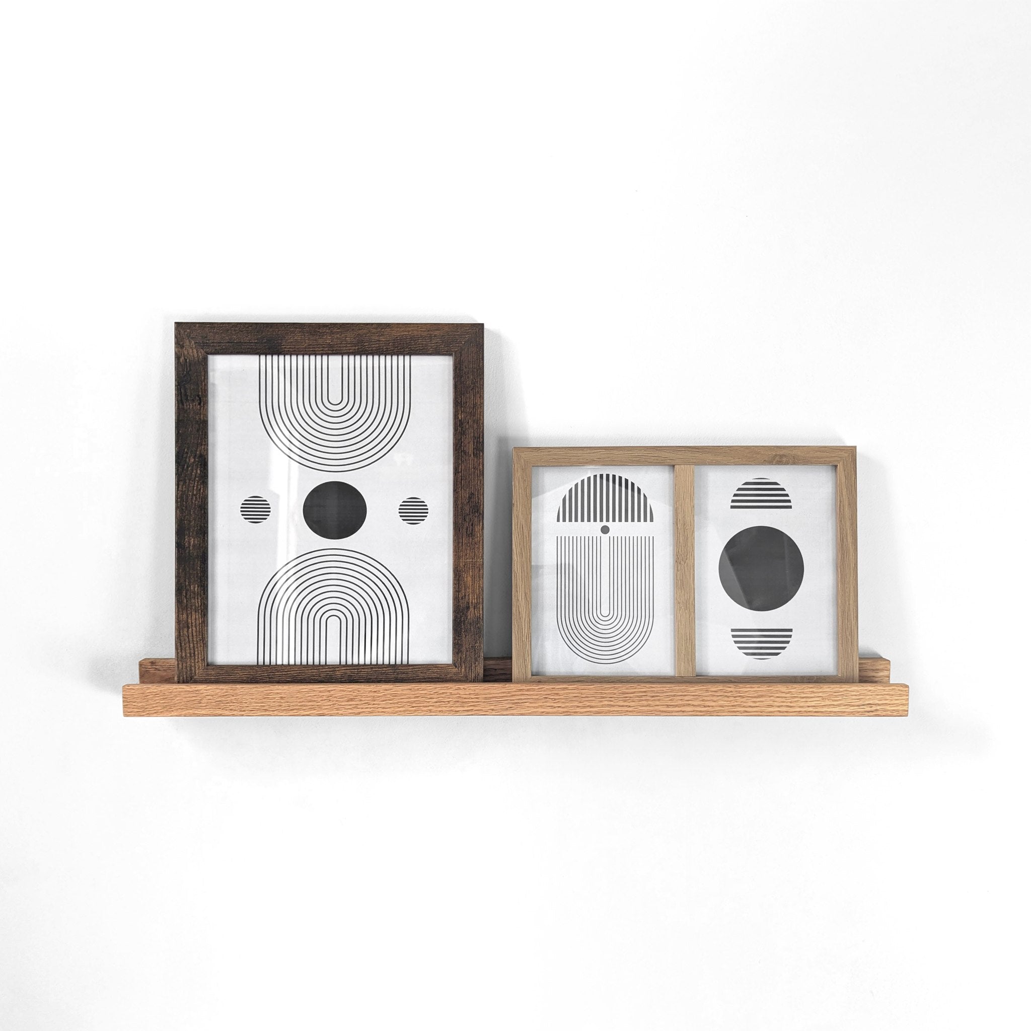 oak wooden picture shelf with two picture frames.