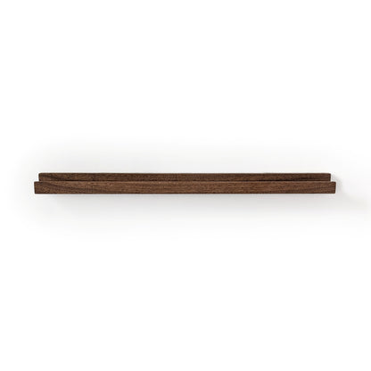 Picture ledge shelf in mahogany with walnut stain on a white wall.