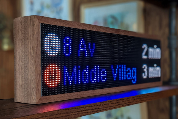 A MTA NYC Realtime Subway Clock is displayed on a shelf with the L subway station and M subway station displayed on the LED screen.