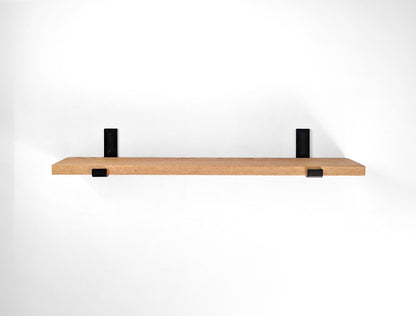 Top view of a long oak shelf with two steel brackets.