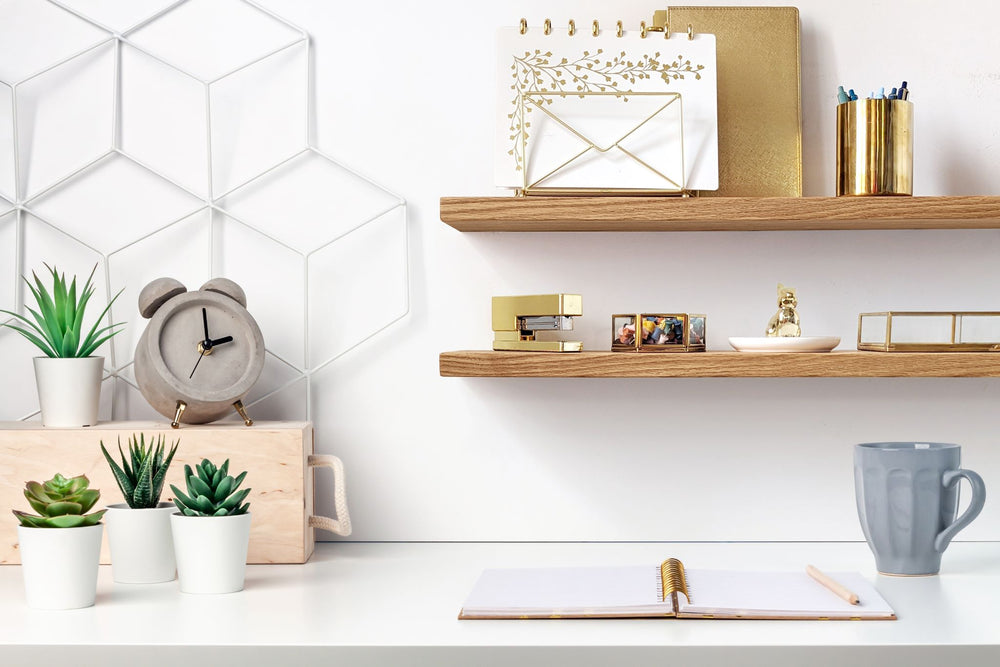 Two thin oak floating shelves installed over an office desk