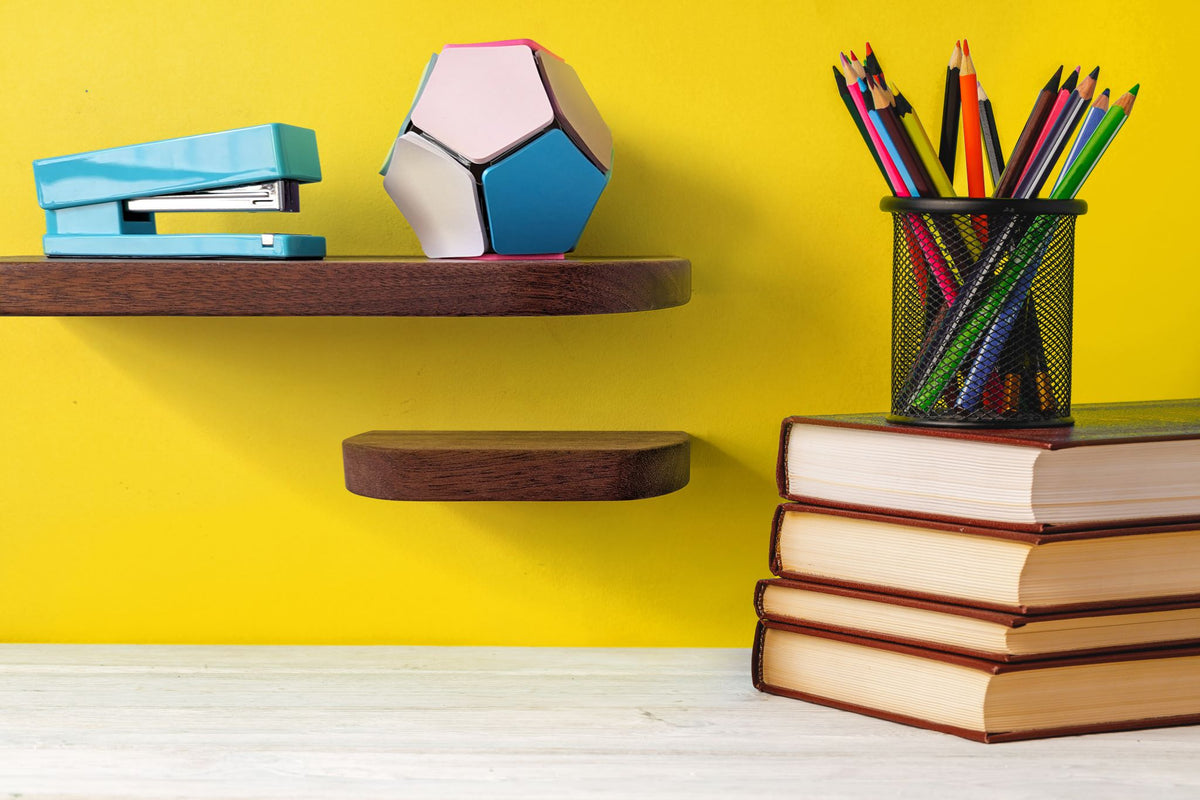 Two thin mahogany shelves with rounded corners are displayed on a wall over a desk.