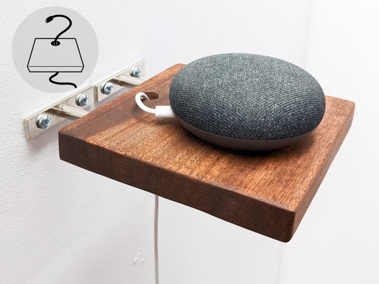 A small round speaker sits on top of a small mahogany square floating shelf that is mid-installation. A wire is plugged into the speaker and easily slips through a drilled hole in the shelf for easy and stylish cord management. 