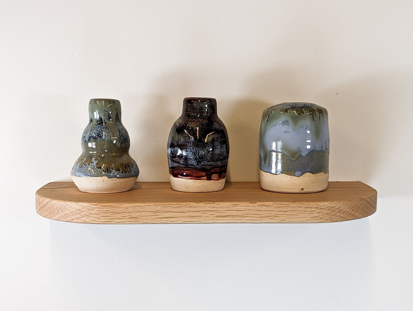 Front view of three vases sitting atop an oak shelf with soft beveled and rounded corners