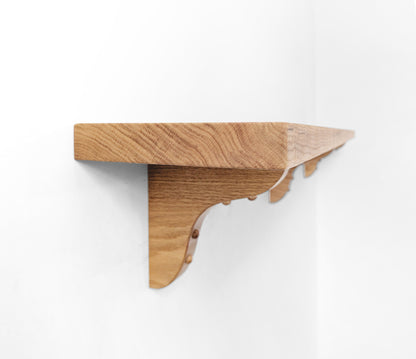 Side view of a wooden shelf with wooden brackets.