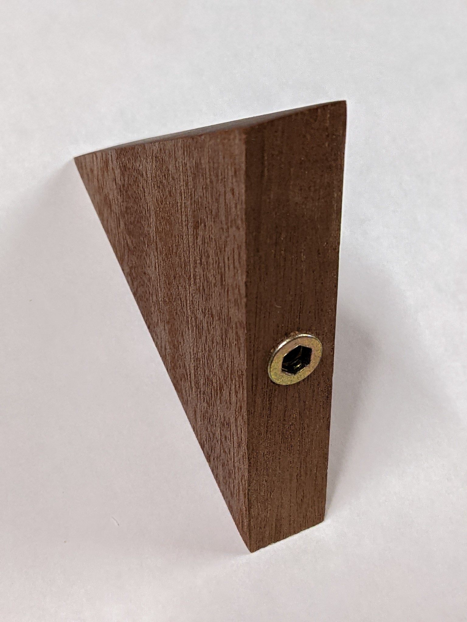 small triangle floating shelf with back exposed revealing where the hole the screw is screwed into.