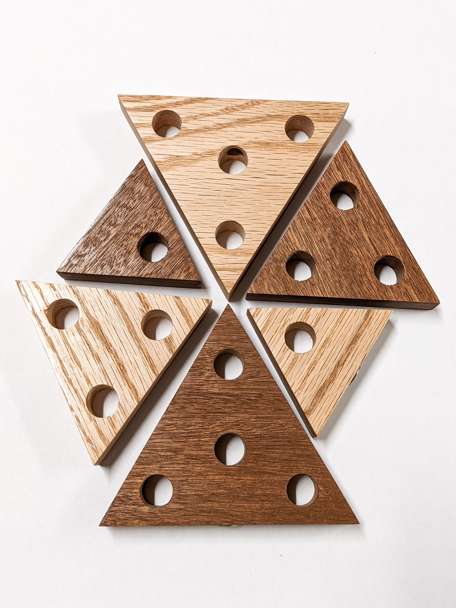 Various sized triangle propagation shelves are arranged on a white background. There is one of both oak and mahogany with 1 hole, three holes, and four holes. 