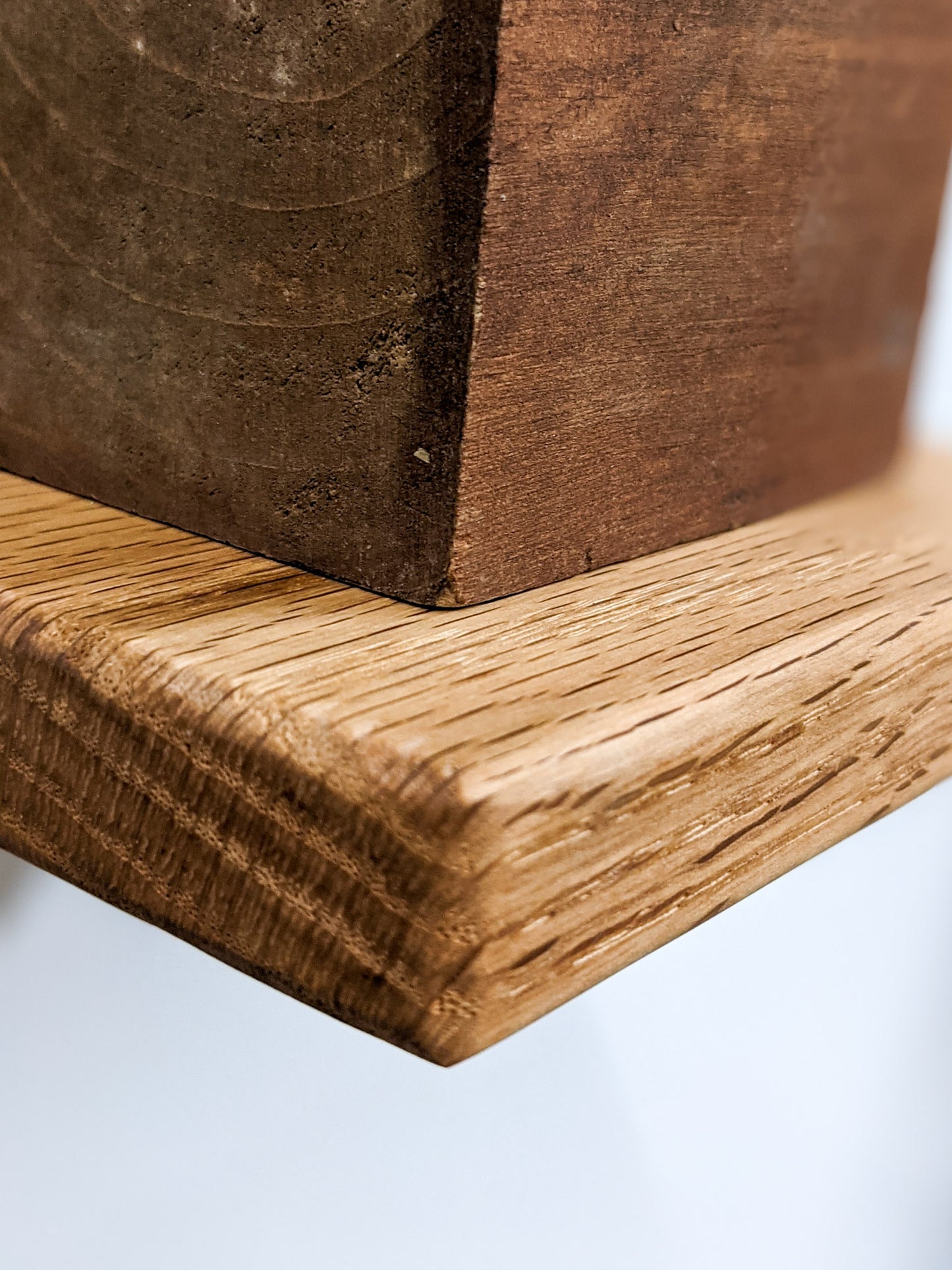 A closeup of the small square floating shelf in oak with soft rounded edges.