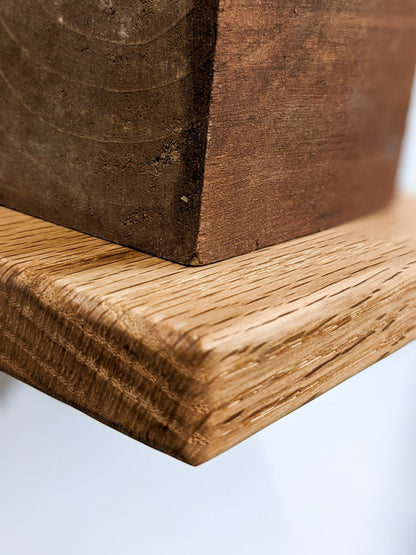A closeup of the small square floating shelf in oak with soft rounded edges.