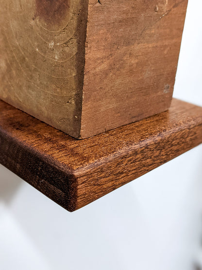A close-up of the small square floating shelf in mahogany with soft rounded edges.